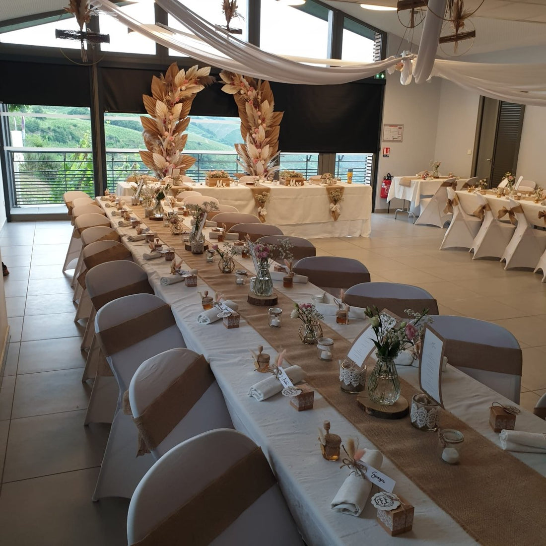 Vue d’ensemble de la table de mariage de Déborah & Sylvain, avec leurs pots de miel en cadeau d’invité